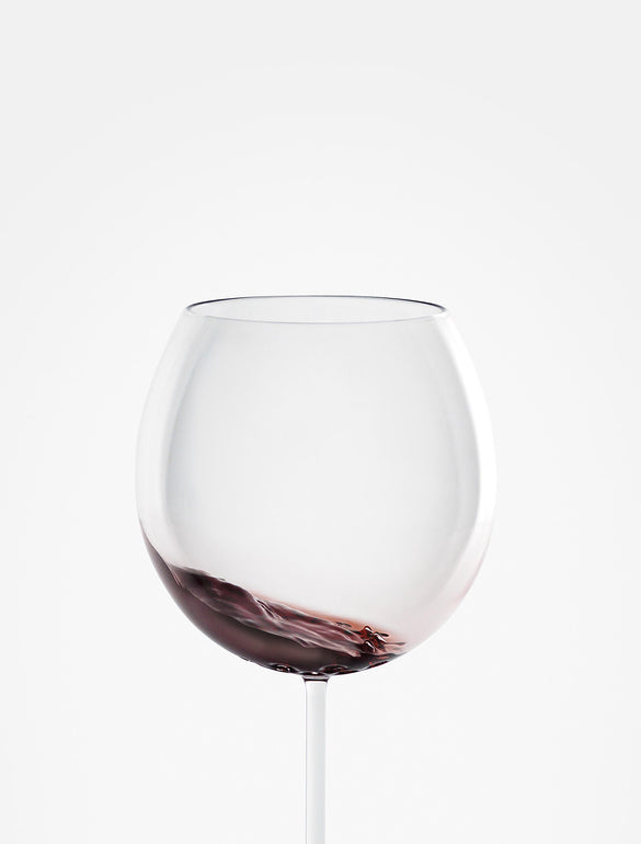 Bicchiere di vino rosso inclinato.
