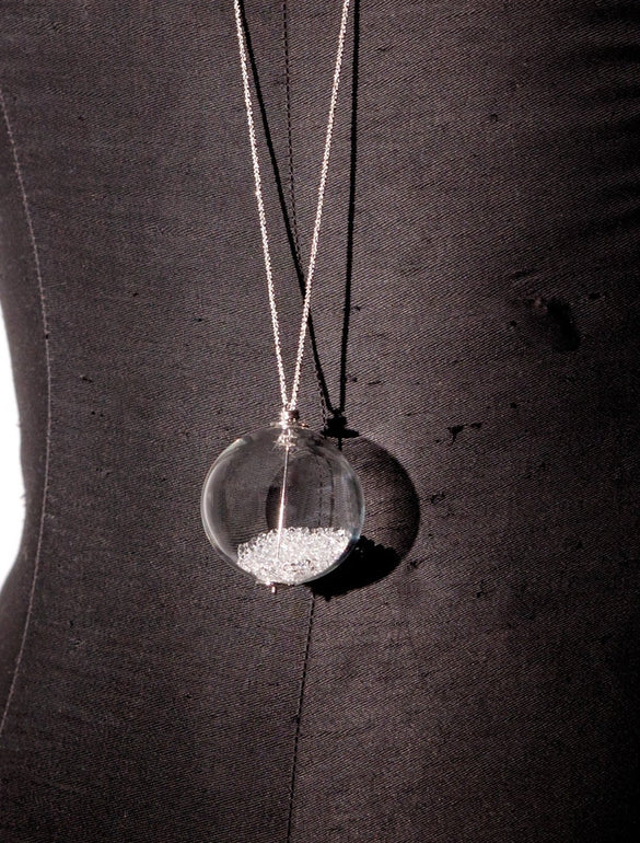 Collana con ciondolo sfera trasparente su sfondo nero
