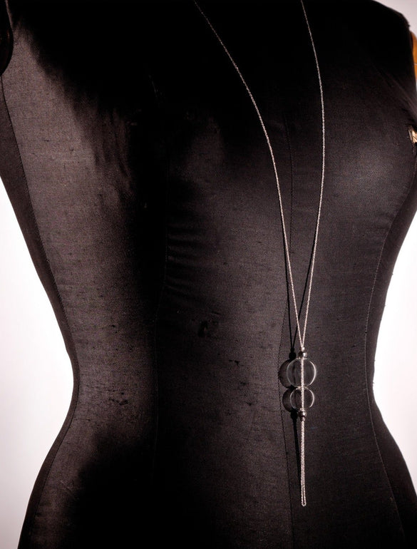 Manichino nero con collana lunga argento e pendente