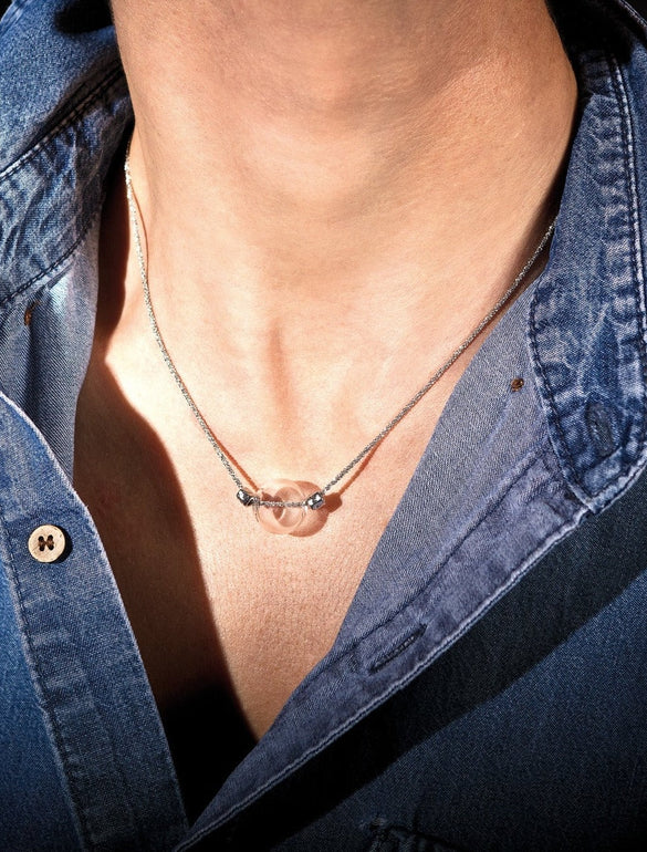 Collana con ciondolo trasparente su camicia di jeans