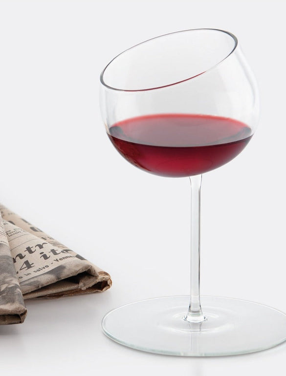 Bicchiere di vino inclinato su giornale