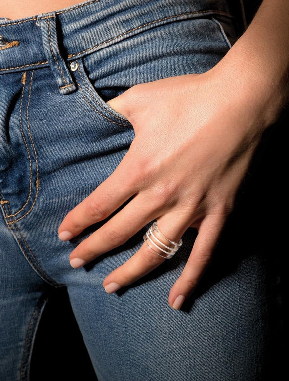 Mano con anelli su jeans