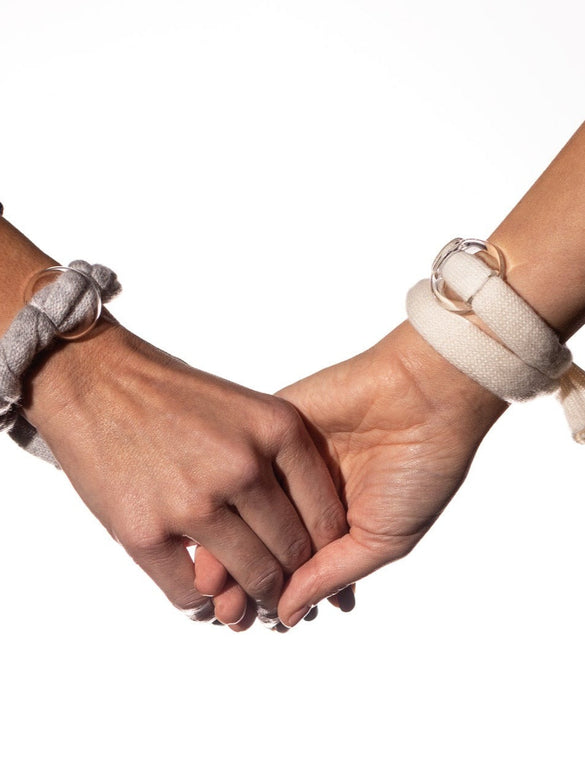 Mani unite con braccialetti di stoffa