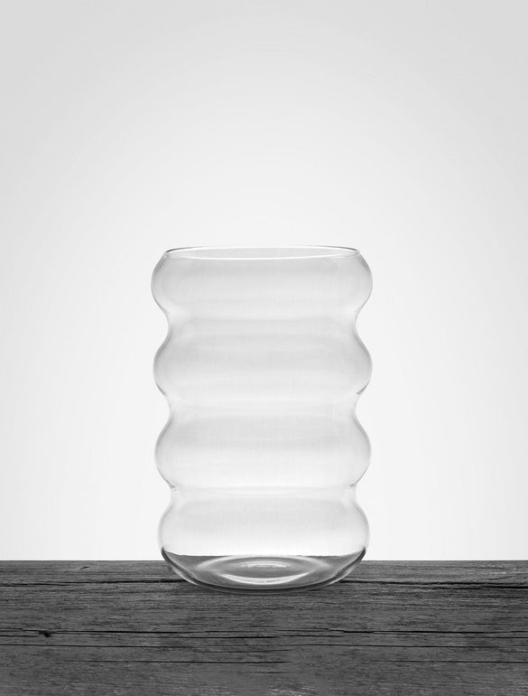 Vaso trasparente ondulato su sfondo grigio chiaro